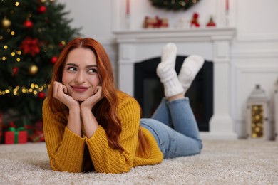 Beautiful young woman in room decorated for Christmas