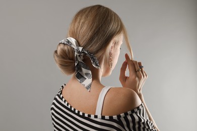 Photo of Woman with stylish bandana on light grey background