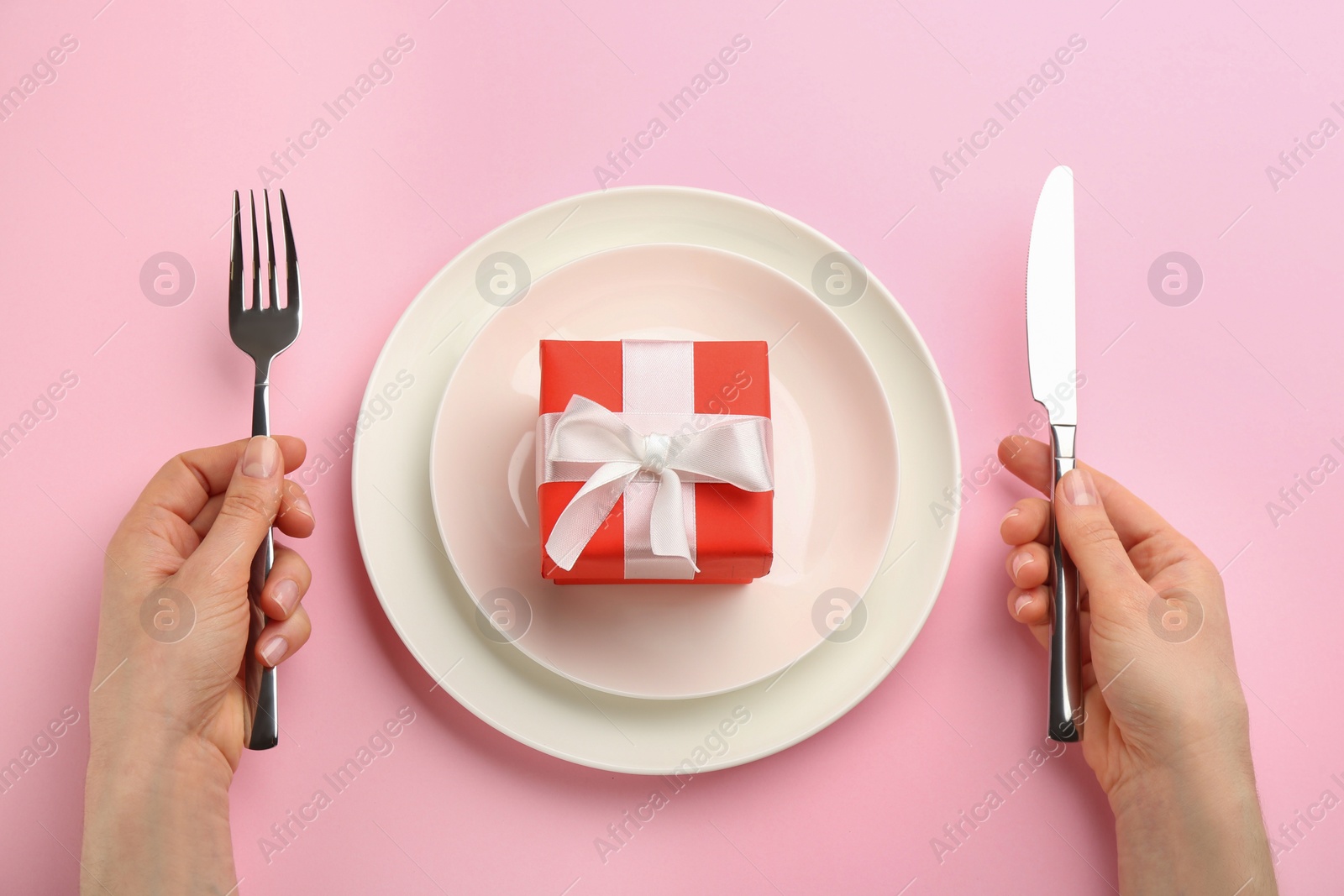 Photo of Woman setting table for Valentine's Day dinner, top view