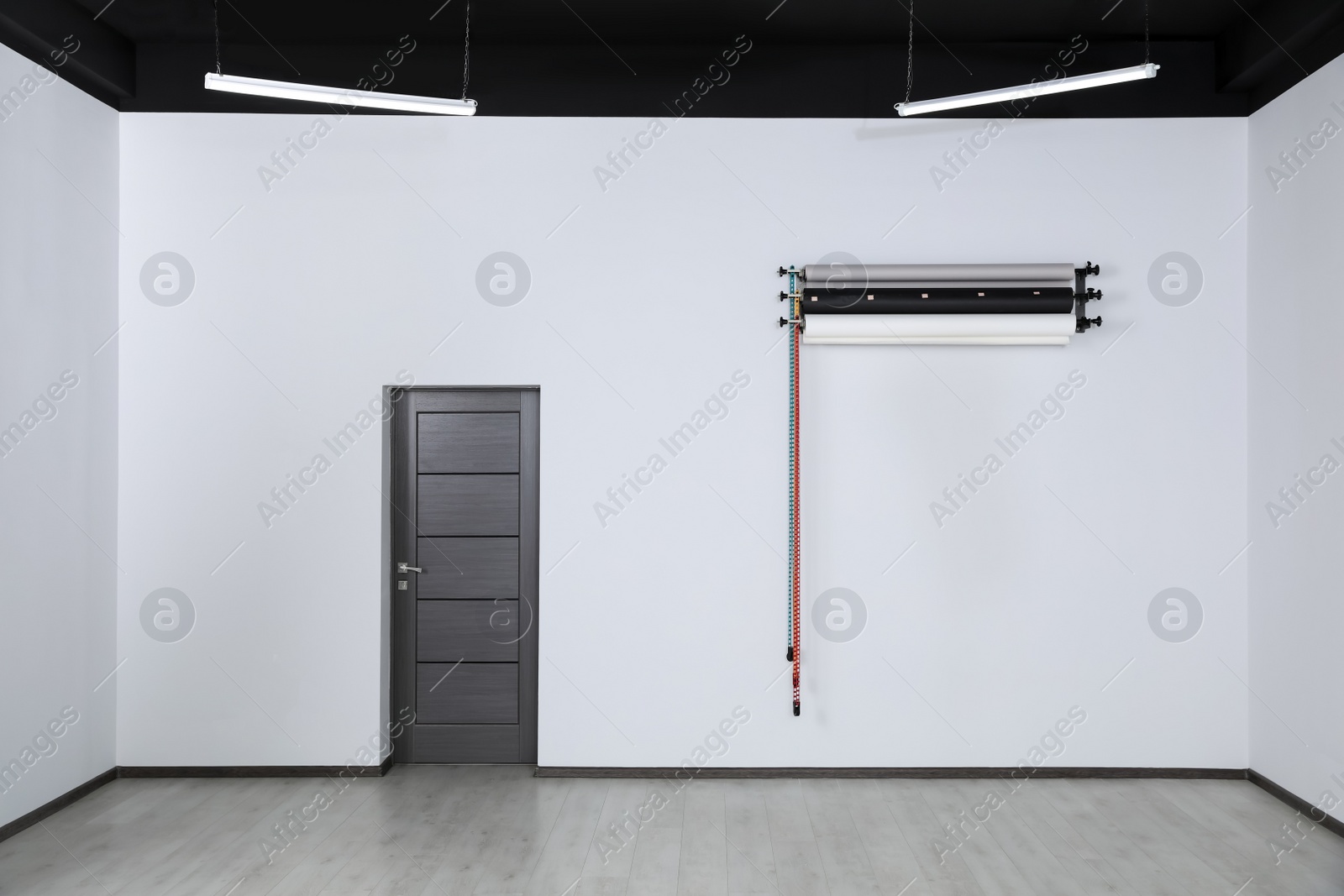 Photo of Colorful photo background rolls near door in office. Interior design