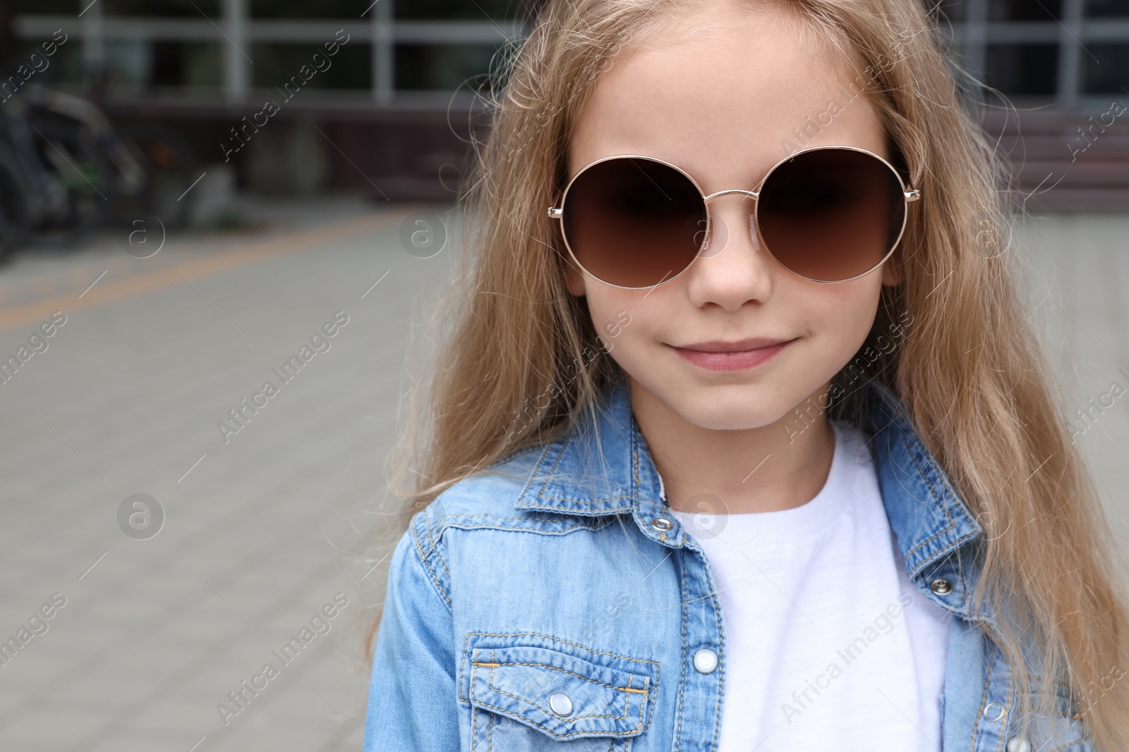 Photo of Girl wearing stylish sunglasses on street near building