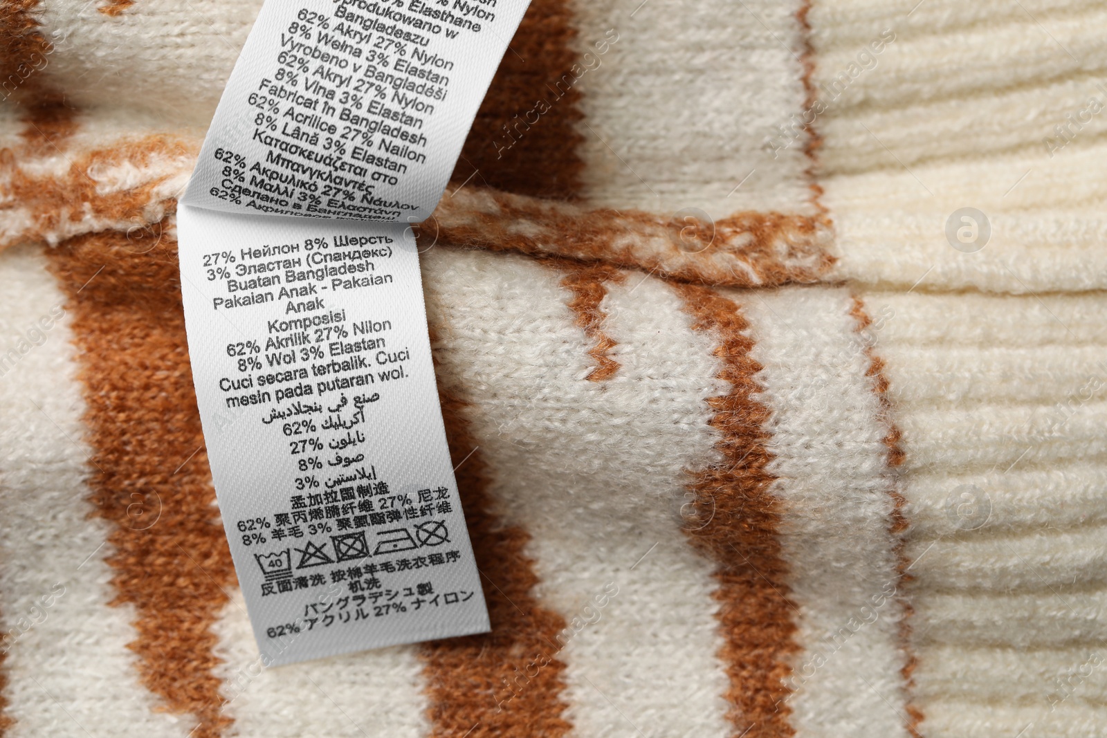 Photo of Clothing labels on knitted garment, top view. Space for text