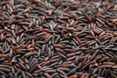 Pile of uncooked black rice as background, closeup