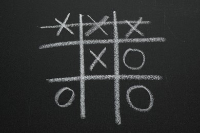 Photo of Tic tac toe game on blackboard, top view