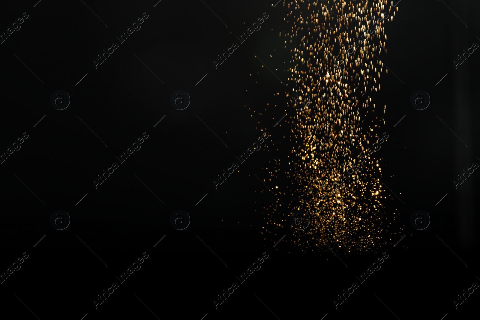 Photo of Shiny golden glitter falling down on black background, space for text. Bokeh effect