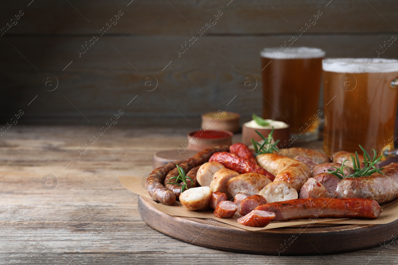 Photo of Set of different tasty snacks and beer on wooden table, space for text