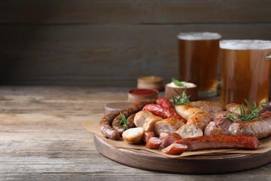 Set of different tasty snacks and beer on wooden table, space for text