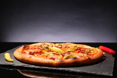 Photo of Delicious pizza Diablo on slate board against grey background