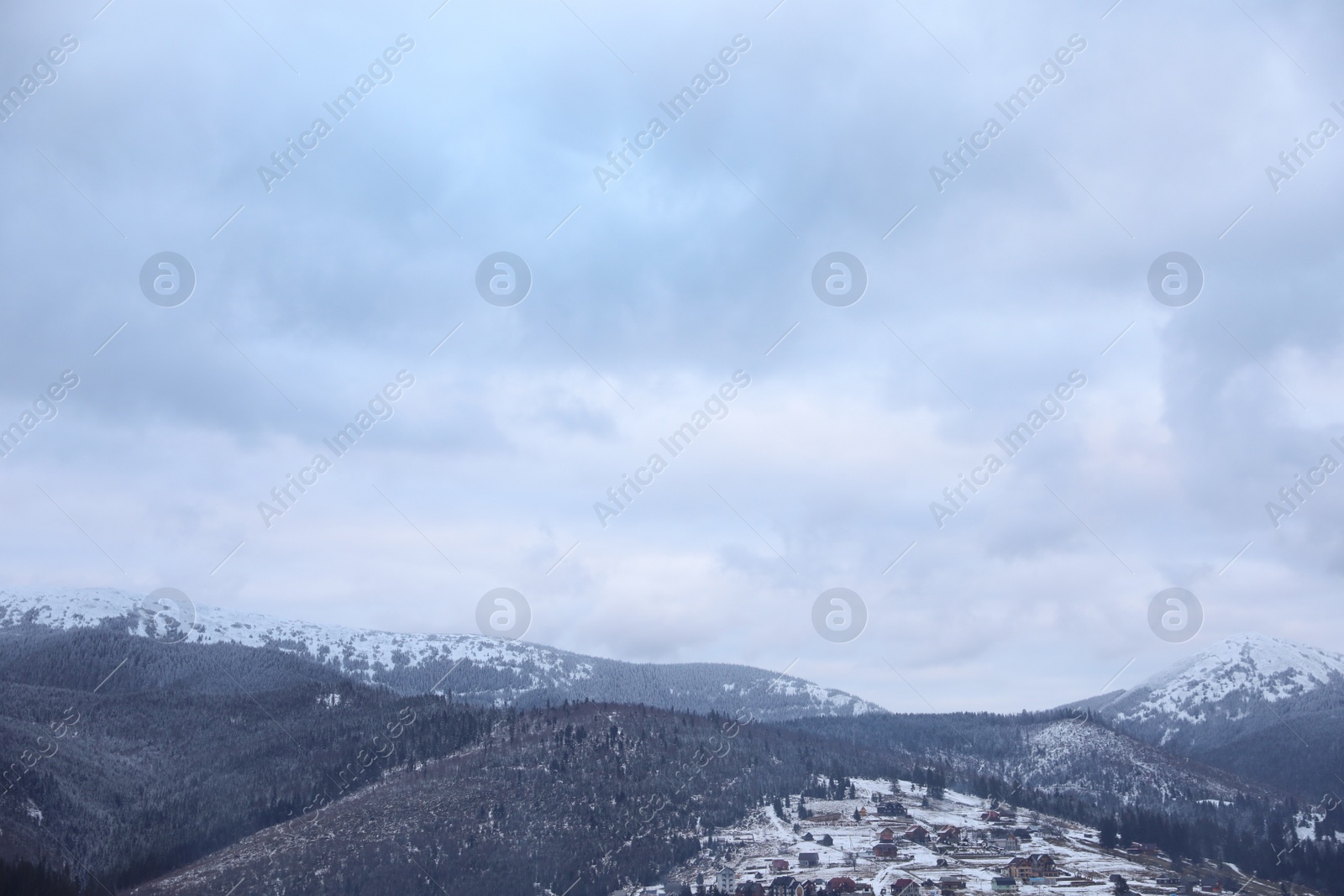 Photo of Winter landscape with mountain village near conifer forest