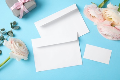 Photo of Flat lay composition with beautiful ranunculus flowers and envelopes on color background. Space for text