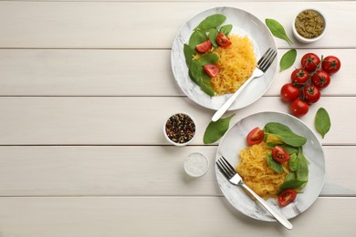 Photo of Tasty spaghetti squash with tomatoes and basil 
served on white wooden table, flat lay. Space for text