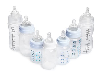 Photo of Many different empty feeding bottles for baby milk on white background