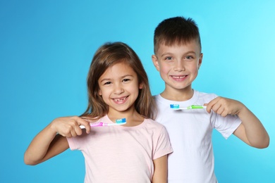 Photo of Portrait of cute children with toothbrushes on color background