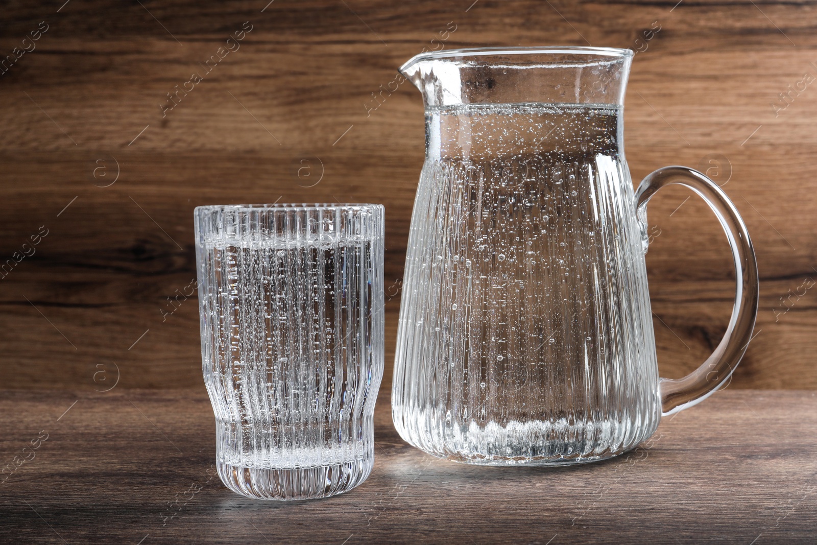 Photo of Glassware with soda water on wooden table