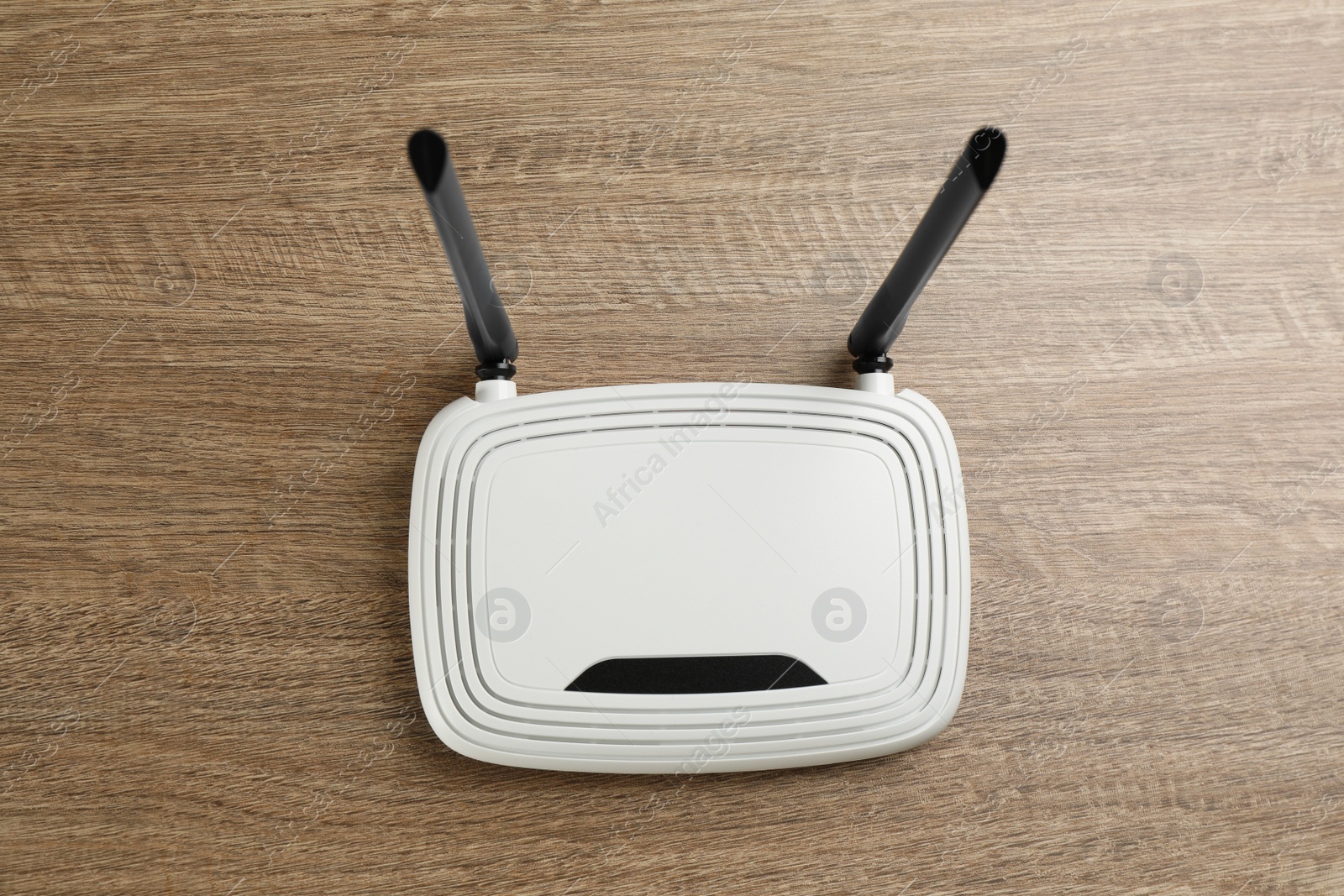 Photo of Modern Wi-Fi router on wooden background, top view