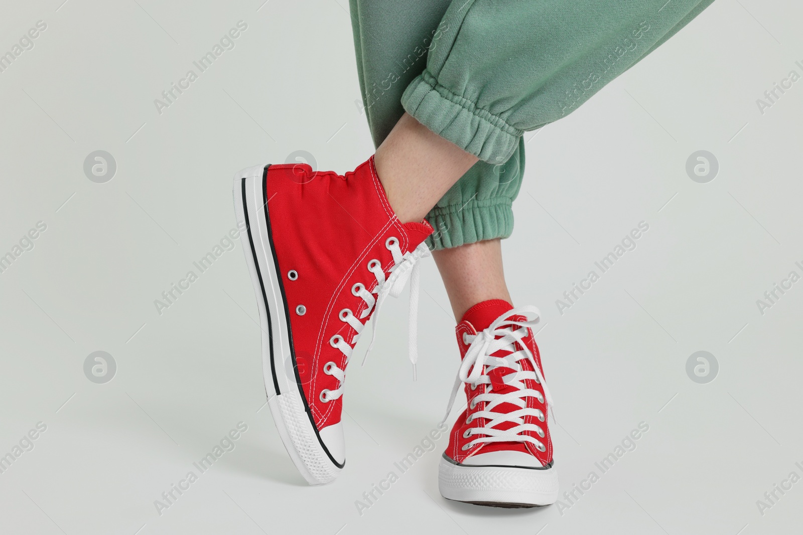 Photo of Woman in stylish gumshoes on white background, closeup