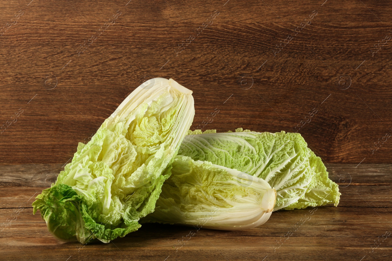 Photo of Cut fresh ripe Chinese cabbage on wooden table