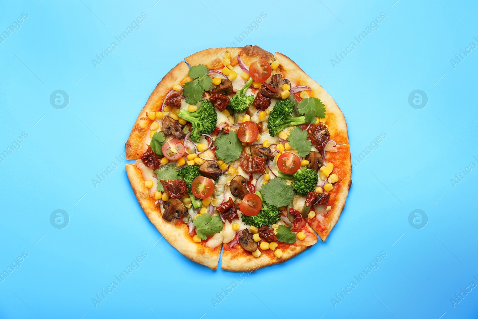 Photo of Delicious vegetarian pizza with mushrooms, vegetables and parsley on light blue background, top view