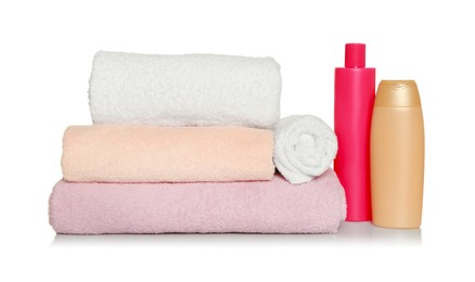 Soft terry towels and cosmetic products on white background
