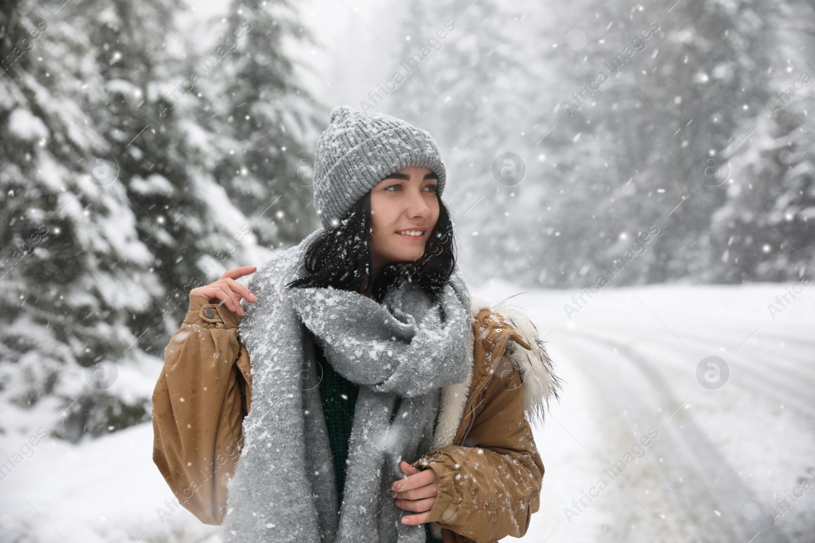 Photo of Young woman wearing warm clothes outdoors on snowy day. Winter vacation