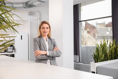 Photo of Female real estate agent indoors. Space for text