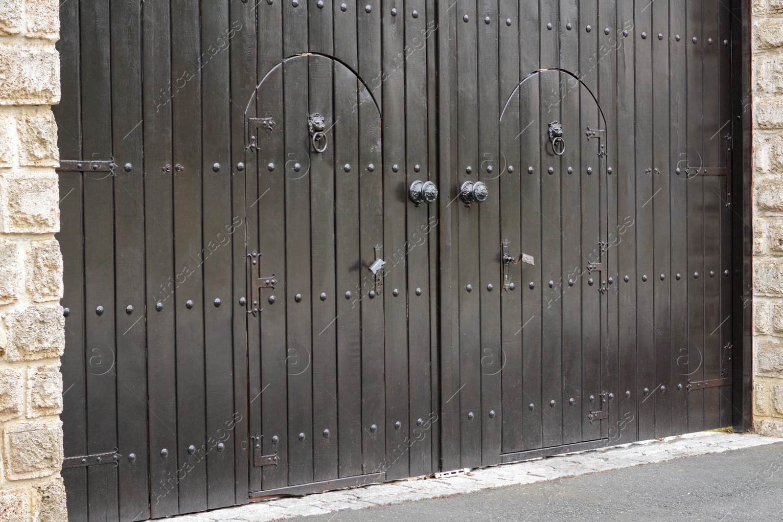 Photo of View of beautiful arched wooden doors outdoors