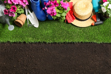 Flat lay composition with gardening equipment and flowers on soil, space for text