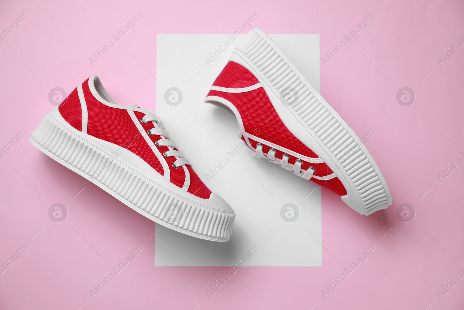 Photo of Pair of red classic old school sneakers on color background, flat lay