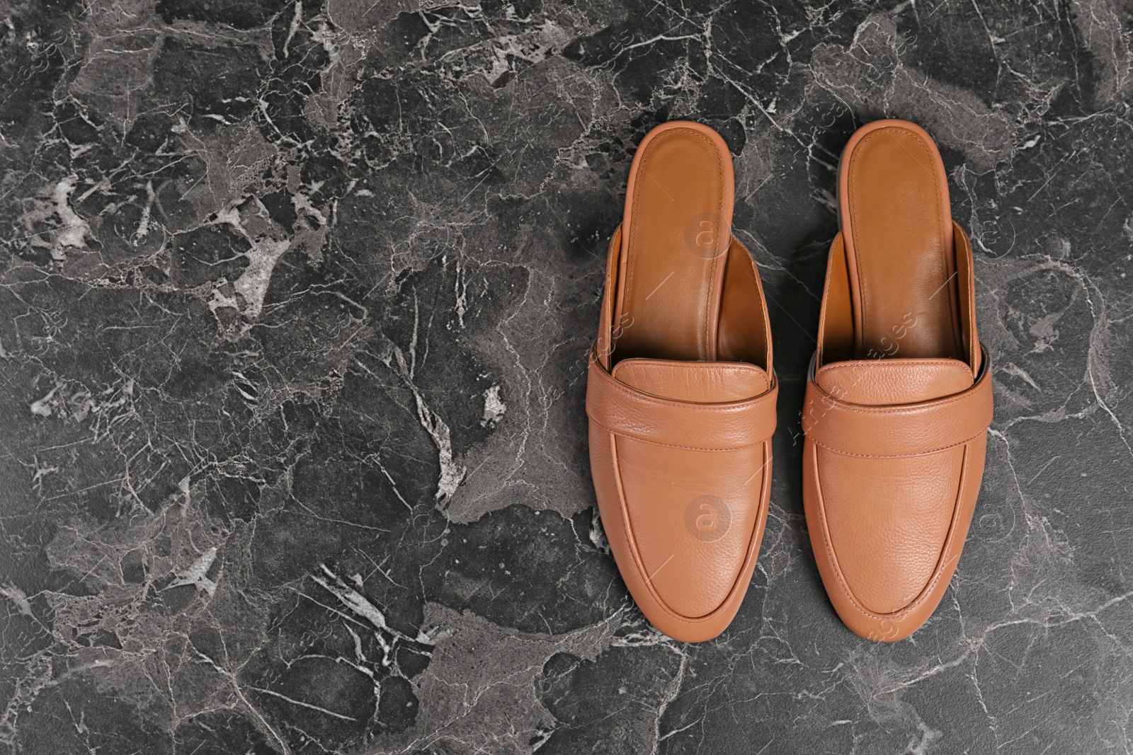 Photo of Pair of female shoes on dark background, top view