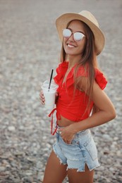 Photo of Beautiful young woman with tasty milk shake on beach