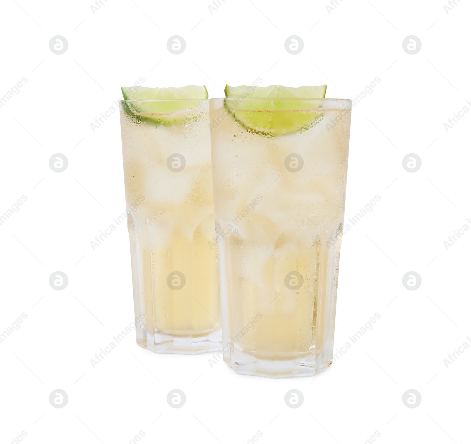 Photo of Glasses of tasty ginger ale with ice cubes and lime slices isolated on white