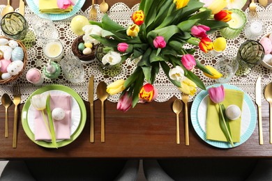 Festive table setting with beautiful flowers, top view. Easter celebration