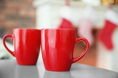 Photo of Red cups and blurred fireplace with Christmas stockings on background