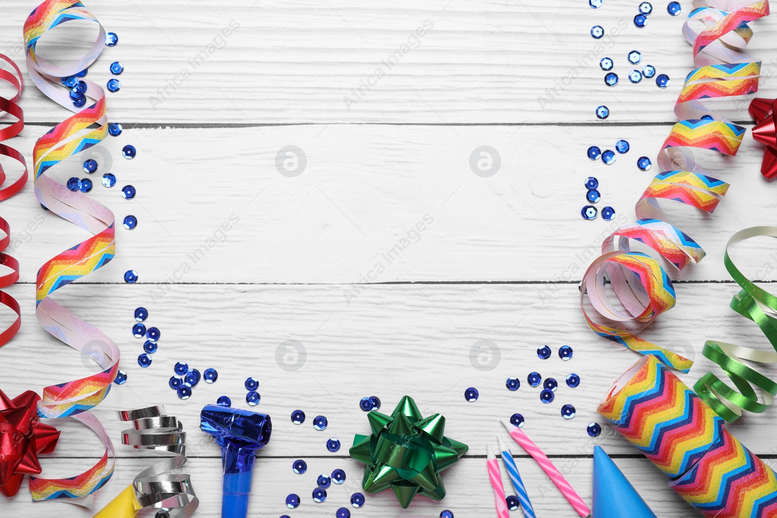 Photo of Flat lay composition with party items on white wooden table, space for text. Birthday celebration