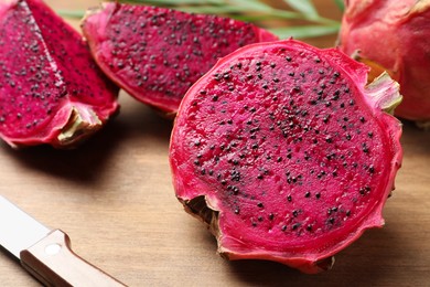 Photo of Delicious cut red pitahaya fruit on wooden board, closeup