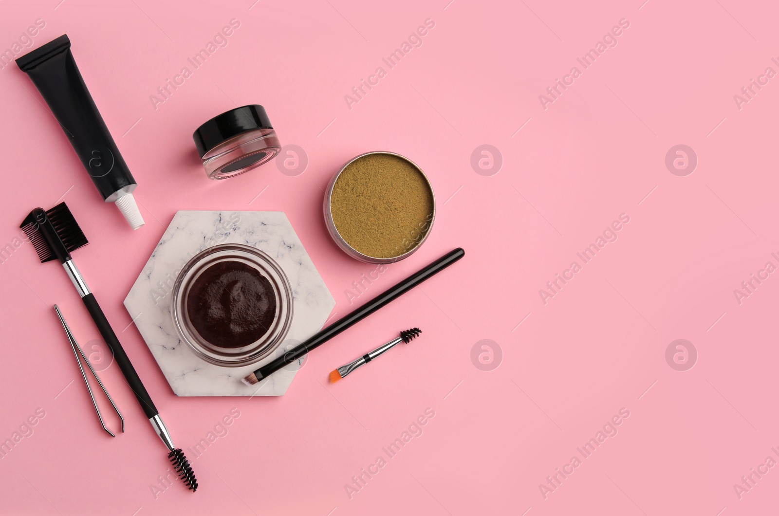 Photo of Flat lay composition with eyebrow henna and tools on pink background. Space for text