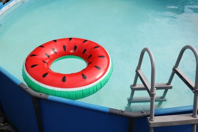 Photo of Inflatable ring floating on water in above ground swimming pool outdoors