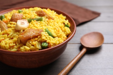 Delicious pilaf with chicken meat on wooden table, closeup