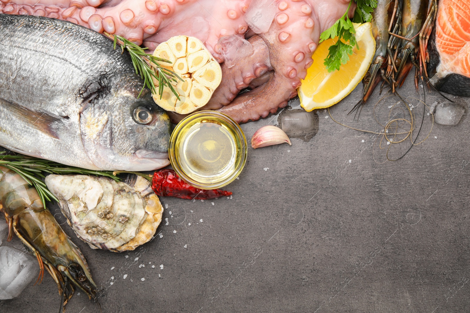 Photo of Flat lay composition with fresh raw dorado fish and different seafood on grey table. Space for text