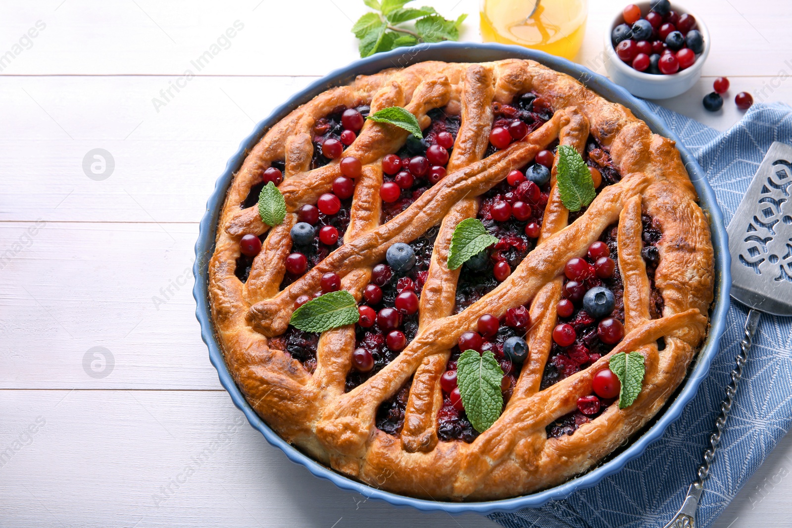 Photo of Delicious currant pie and fresh berries on white wooden table