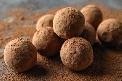 Delicious raw chocolate truffles on grey background