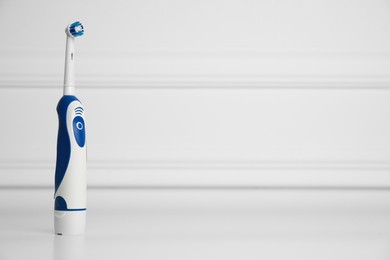 Photo of Electric toothbrush on white background, space for text