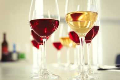 Photo of Glasses with delicious wine on table indoors