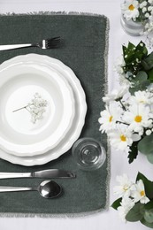 Elegant festive setting with floral decor on table, flat lay