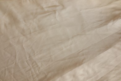 Photo of Crumpled dark beige fabric as background, top view