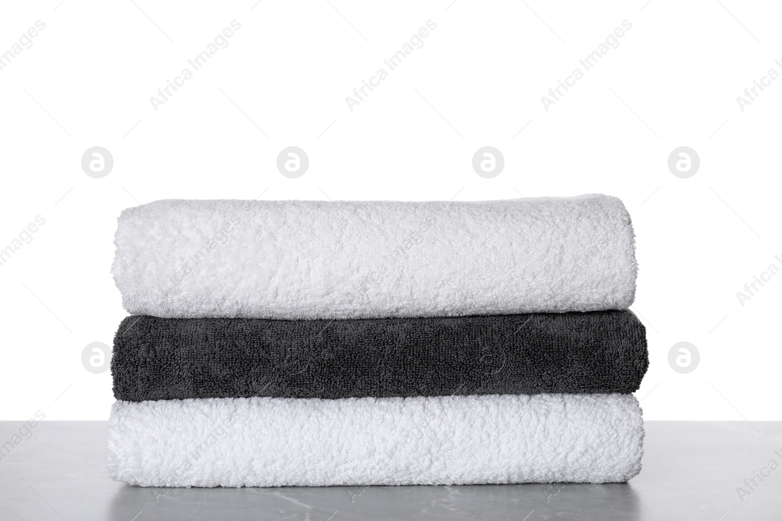 Photo of Stacked soft towels on table against white background