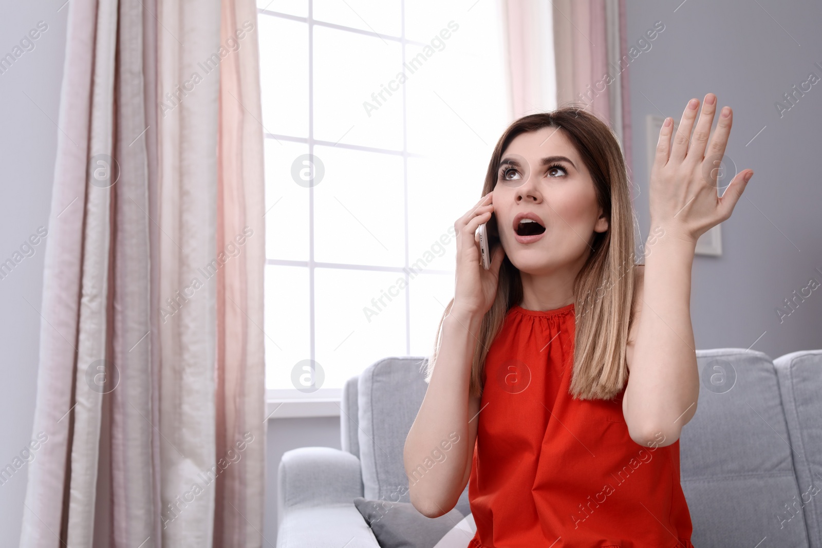 Photo of Woman arguing on mobile phone at home