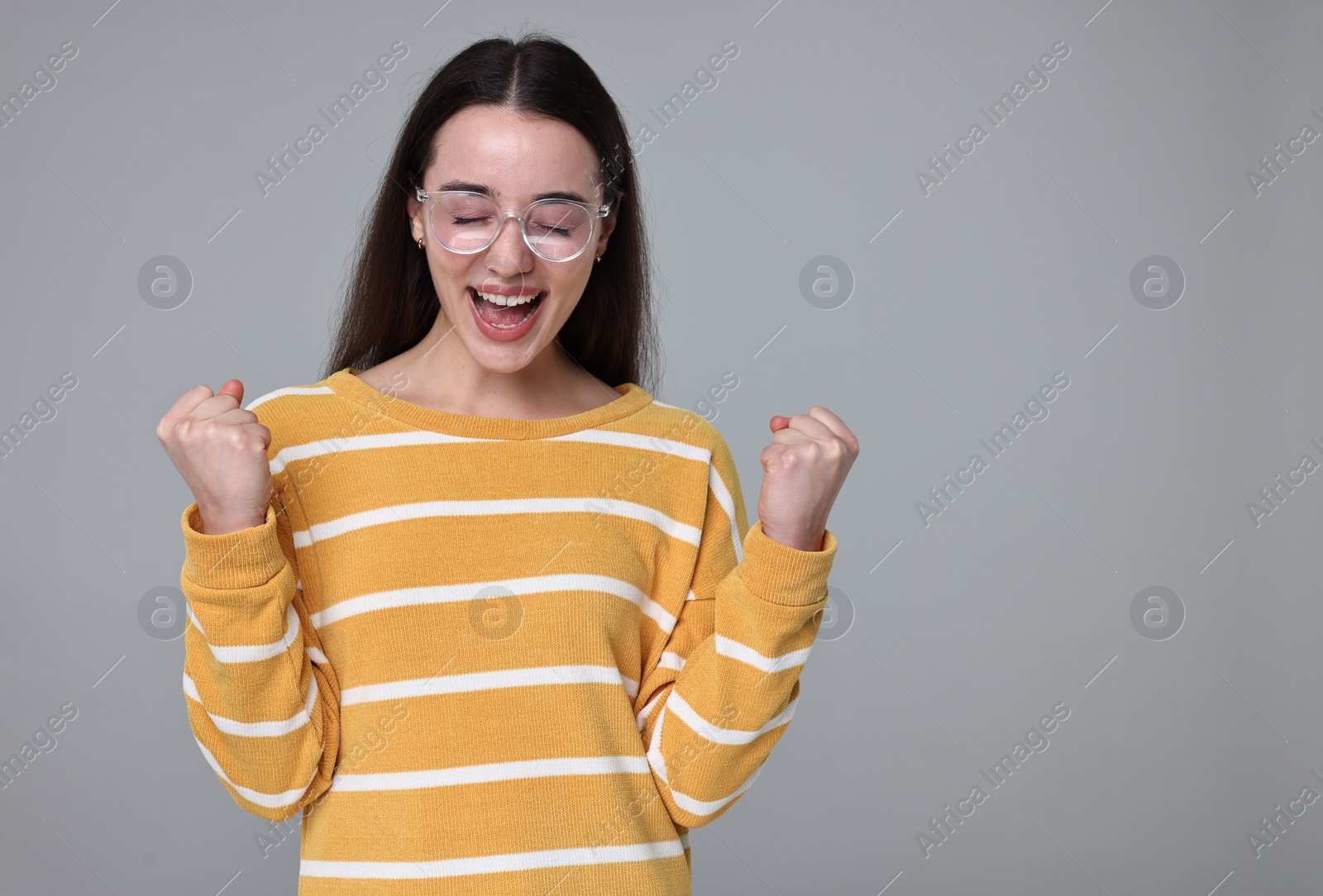 Photo of Portrait of happy surprised woman on grey background. Space for text