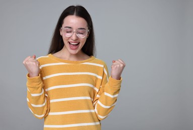 Photo of Portrait of happy surprised woman on grey background. Space for text