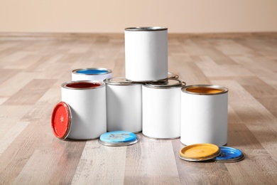 Cans of paint on wooden floor indoors